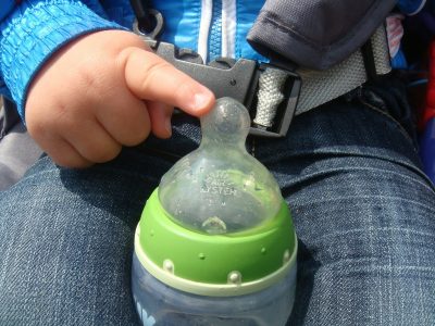 toddler holding bottle of formula